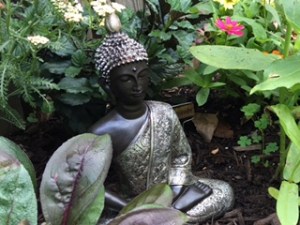 Buddha among my flowers, symbolizing peace.