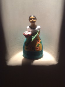 A figure of a hispanic girl offering food