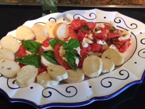 Prepared platter of fresh tomatoes with fresh Basil, Olive Oil & Balsamic Vinegar & French Baguette