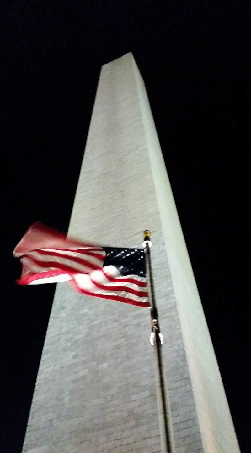 Washington Monument with American Flag lite at night