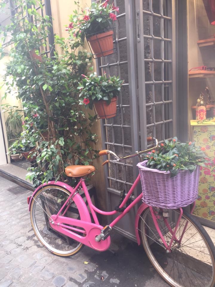 A pink bike with a lilac basket in parked in Tuscany